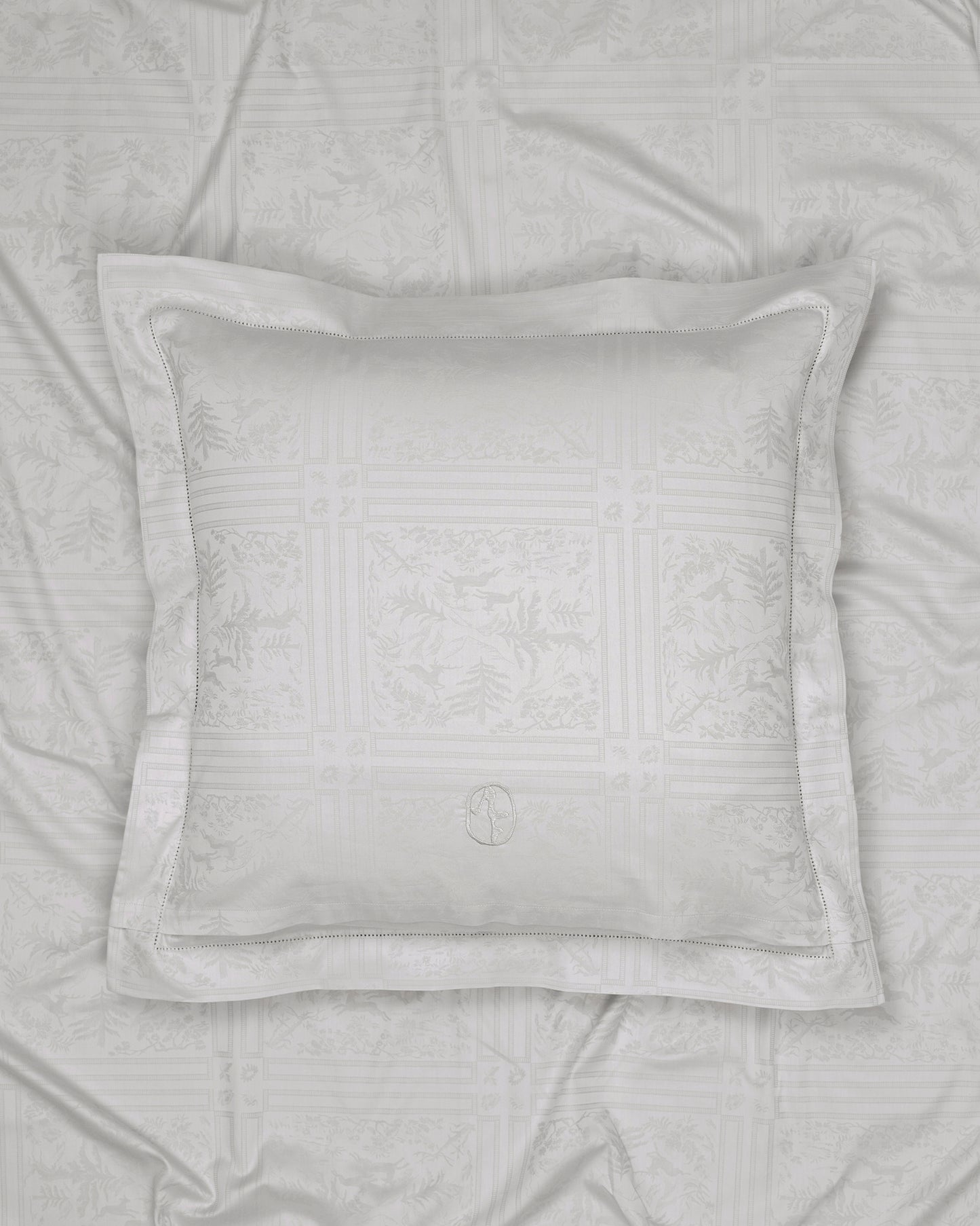 Gray textured pillow on a matching gray quilt