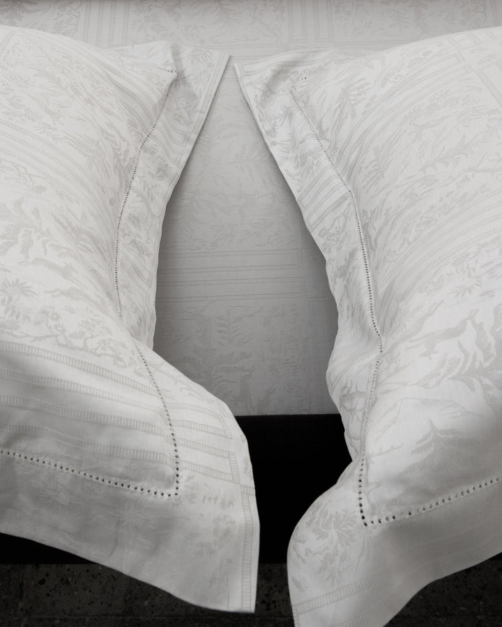 Two white textured pillows on a dark surface