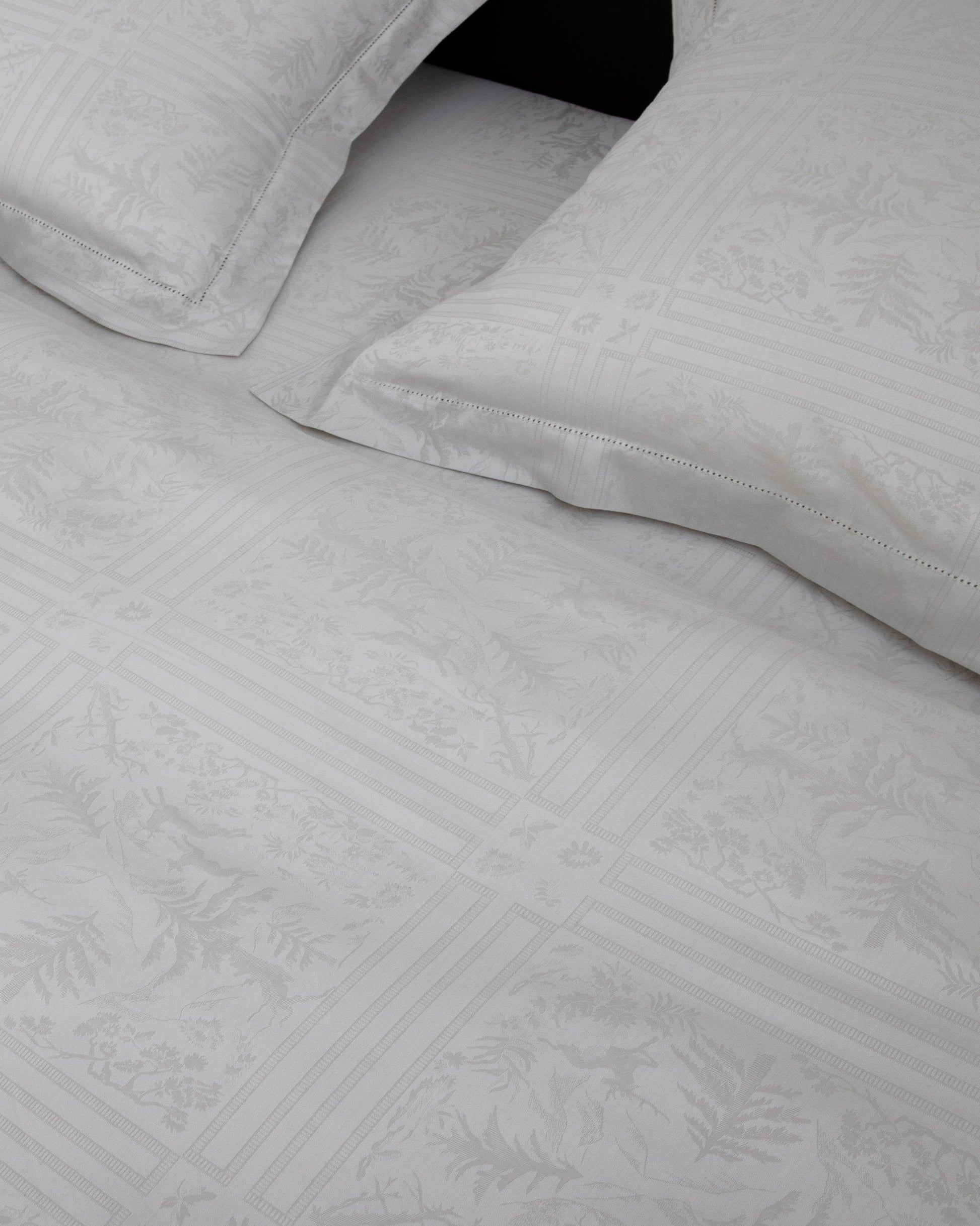 Gray textured bed sheets with folded edges on a black background