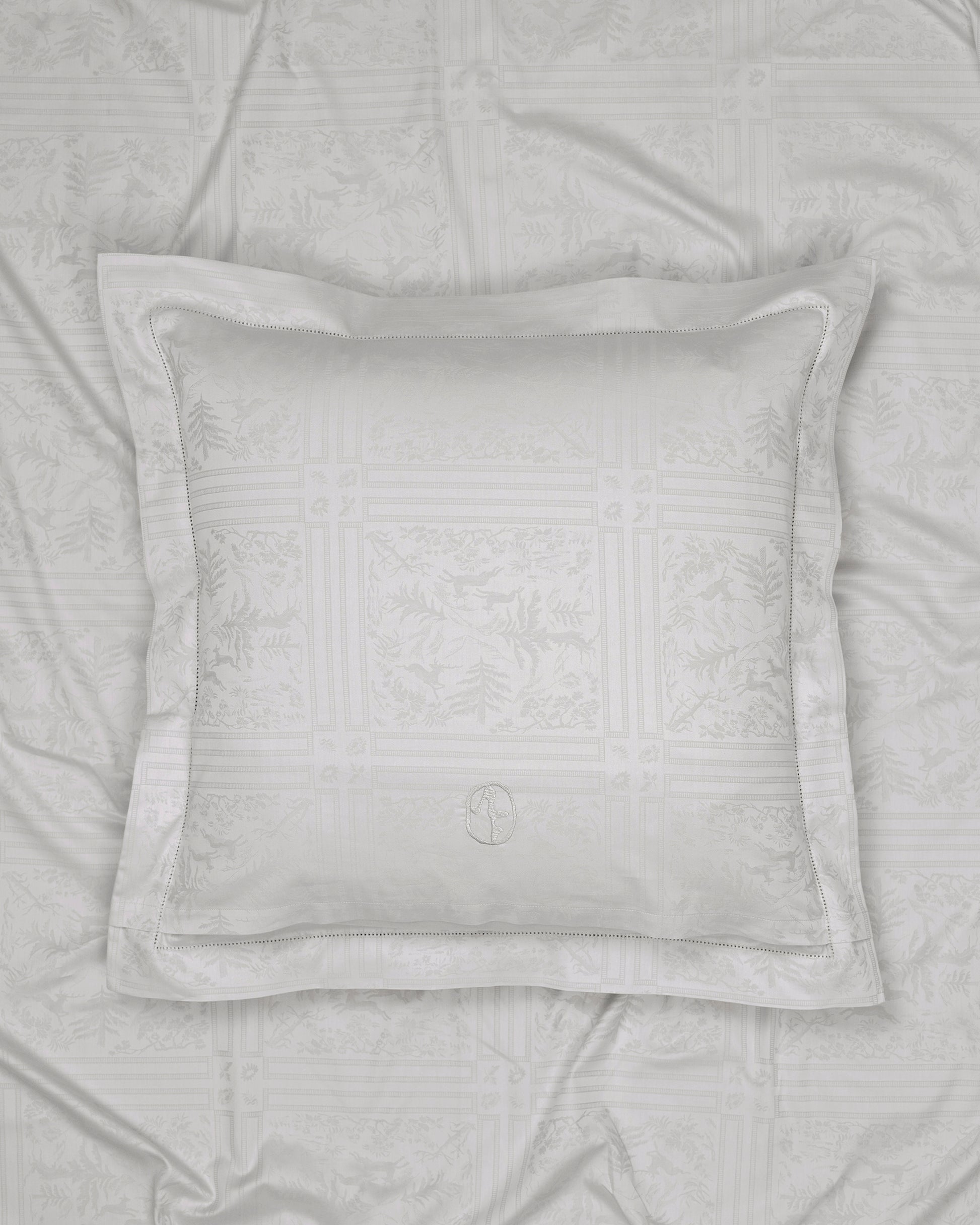 Gray textured pillow on a matching gray quilt