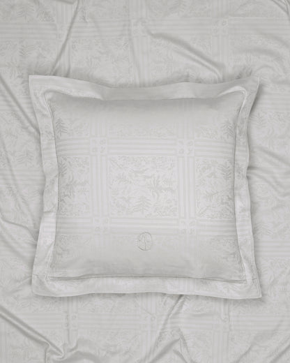 Gray textured pillow on a matching gray quilt